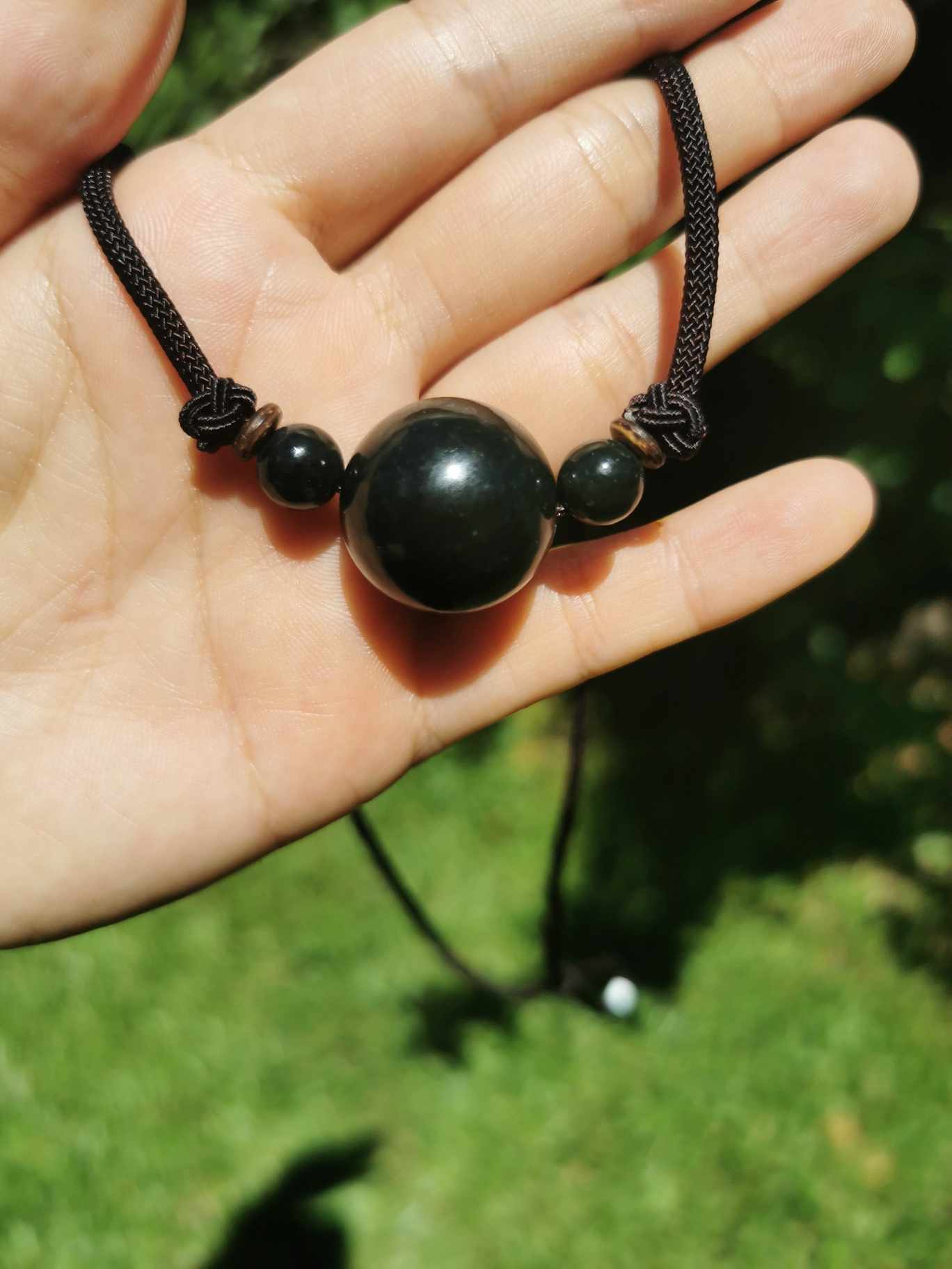 a hand holding Jade turn lucky bead choker