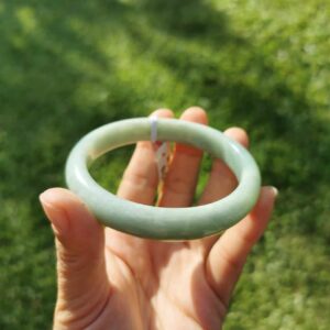 a hand holding Green Jade bangle
