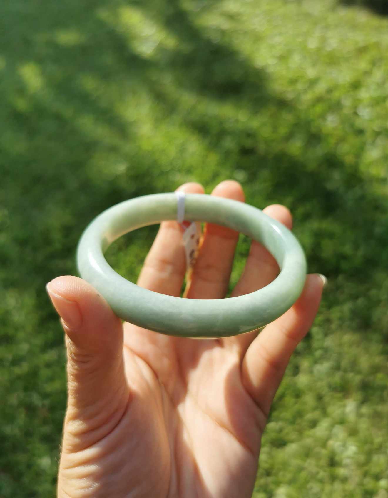 a hand holding Green Jade bangle
