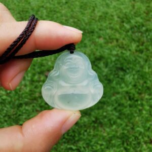 a hand holding White Jade Buddha