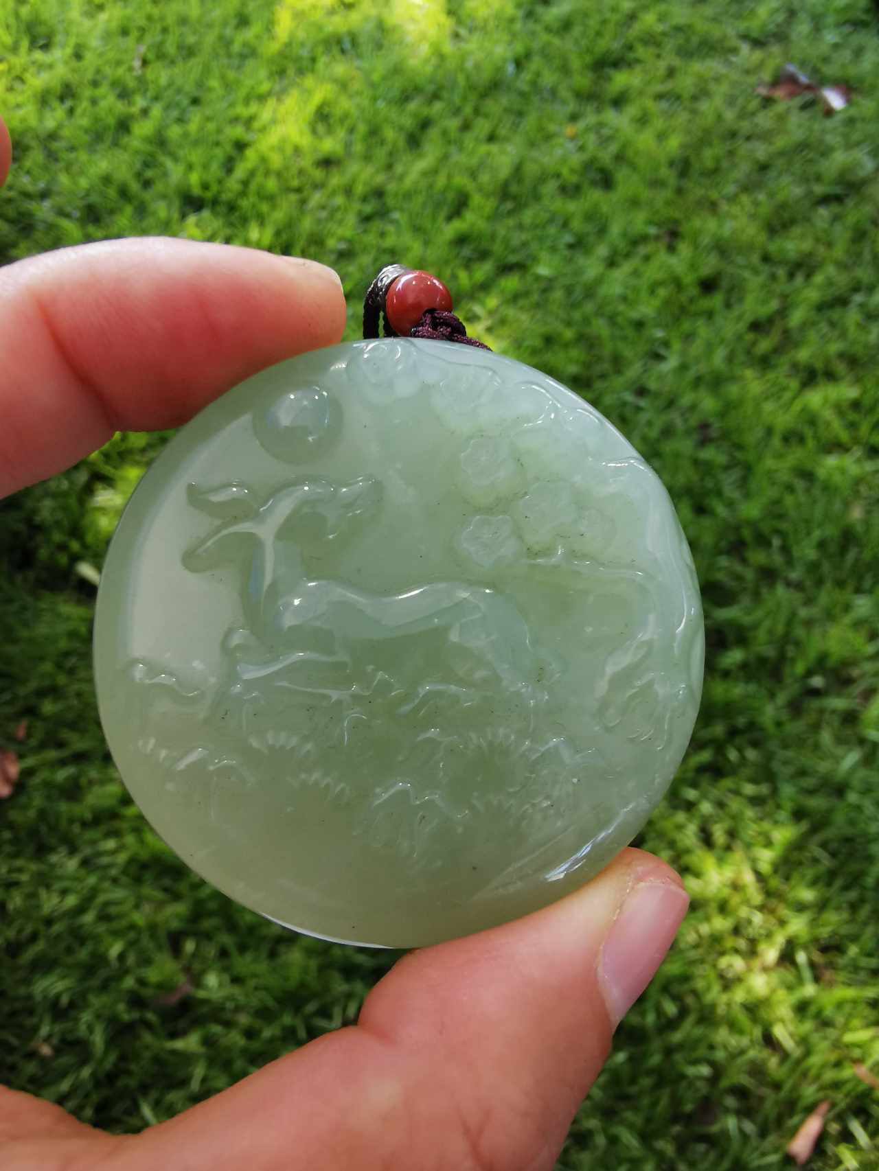 Fingers holding Jade Bambi Pendant