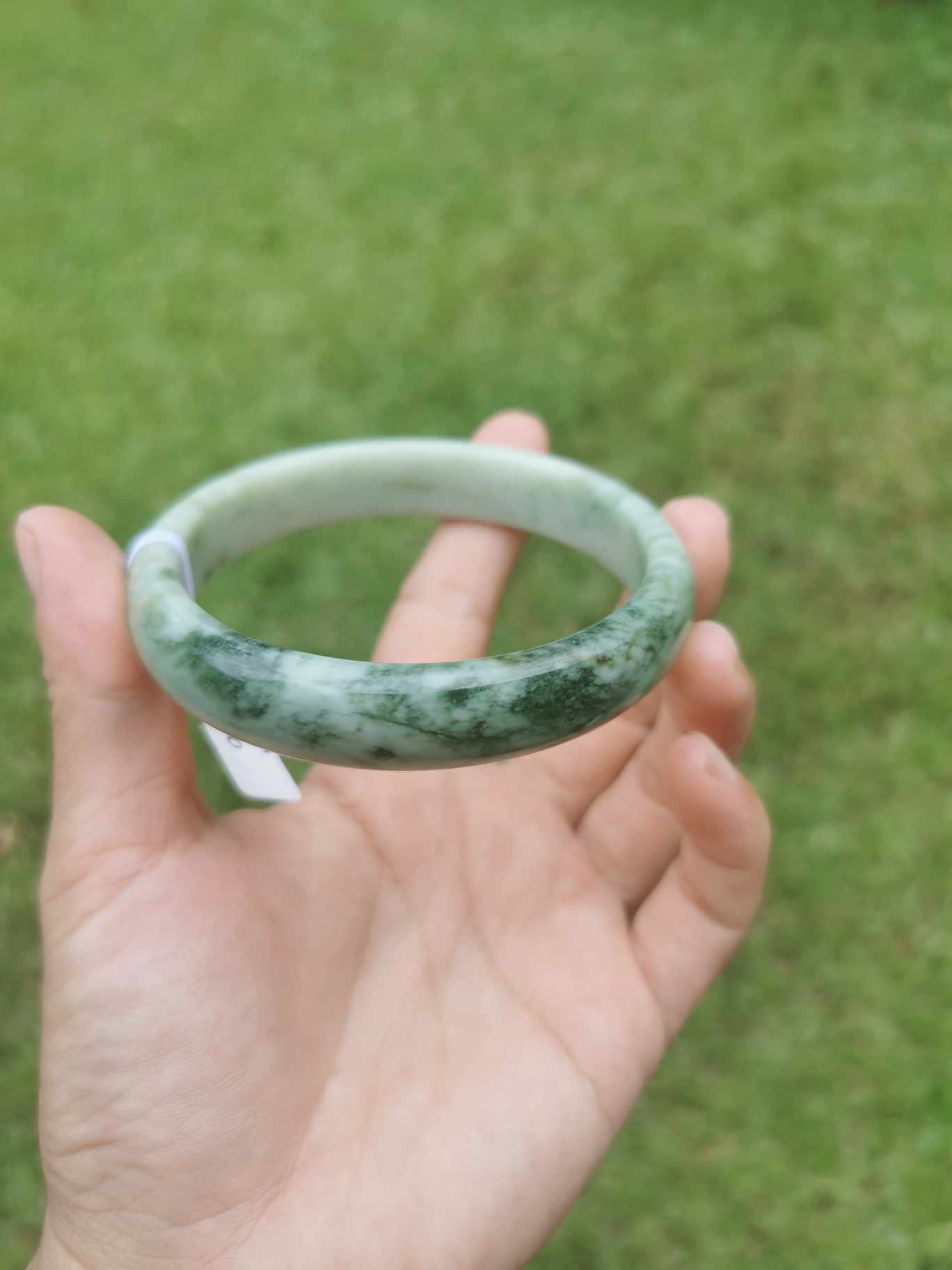 a hand holding Green Jade Bangle